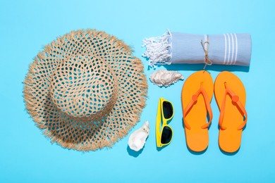 Photo of Flat lay composition with beach towel and other summer accessories on light blue background