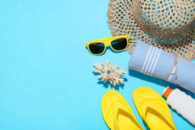 Photo of Flat lay composition with beach towel and other summer accessories on light blue background. Space for text