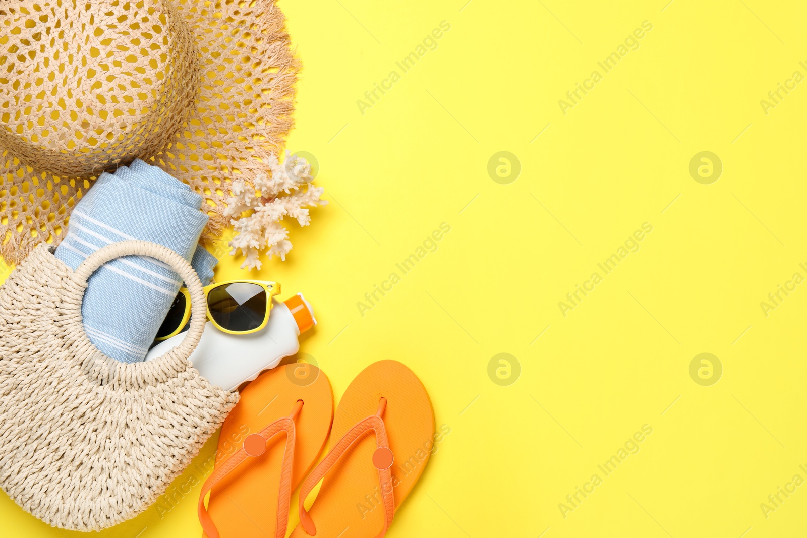 Flat lay composition with beach towel and other summer accessories on yellow background. Space for text Photo of Flat lay composition with beach towel and other summer accessories on yellow background. Space for text