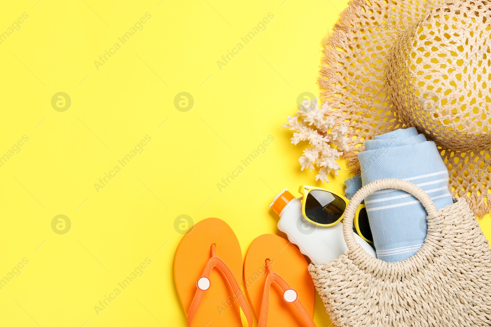 Flat lay composition with beach towel and other summer accessories on yellow background. Space for text Photo of Flat lay composition with beach towel and other summer accessories on yellow background. Space for text