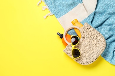 Photo of Flat lay composition with beach towel and other summer accessories on yellow background. Space for text