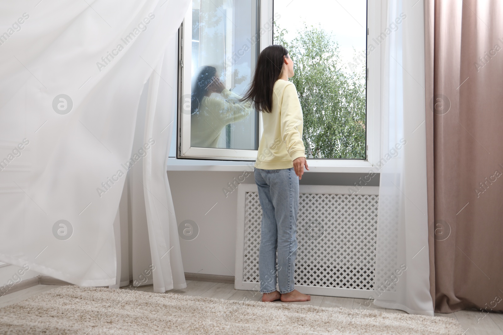 Harmony. Woman near open window at home Photo of Harmony. Woman near open window at home