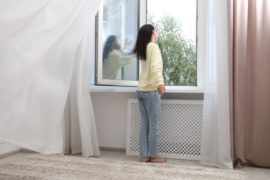 Photo of Harmony. Woman near open window at home