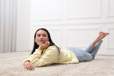 Photo of Harmony. Woman lying on floor near white wall at home