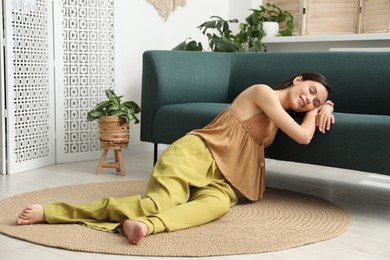 Photo of Harmony. Smiling woman relaxing while leaning on sofa at home