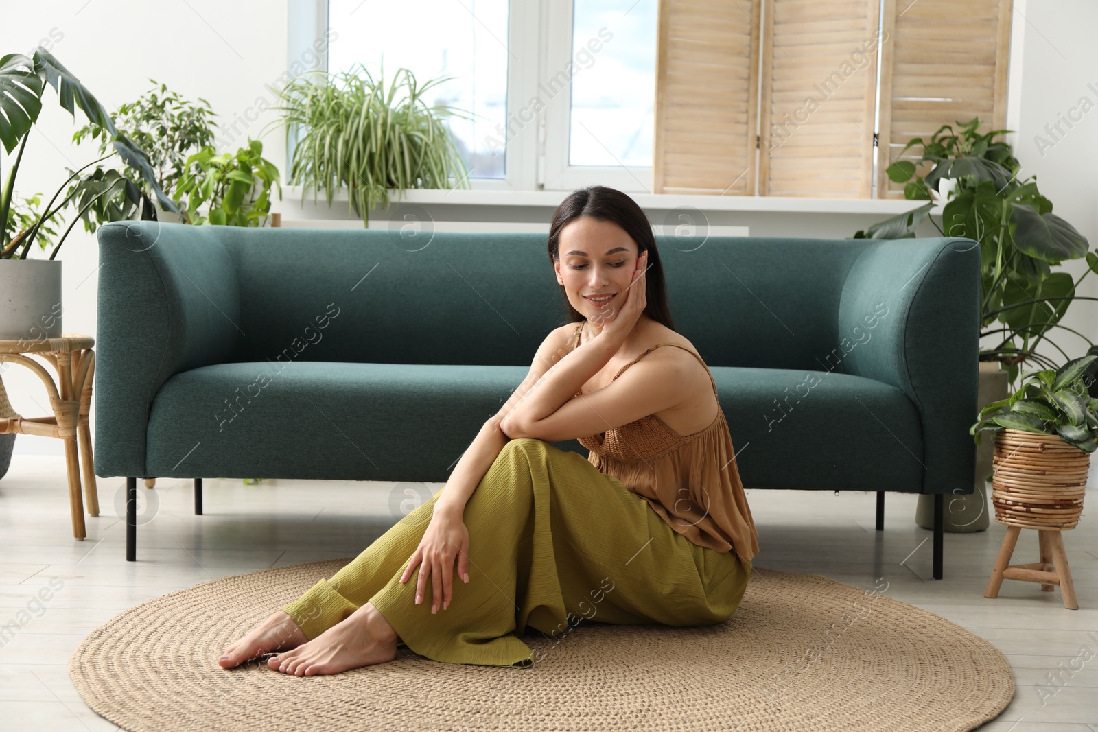 Photo of Harmony. Smiling woman sitting on floor at home