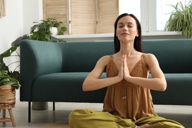 Photo of Harmony. Beautiful woman meditating on floor at home