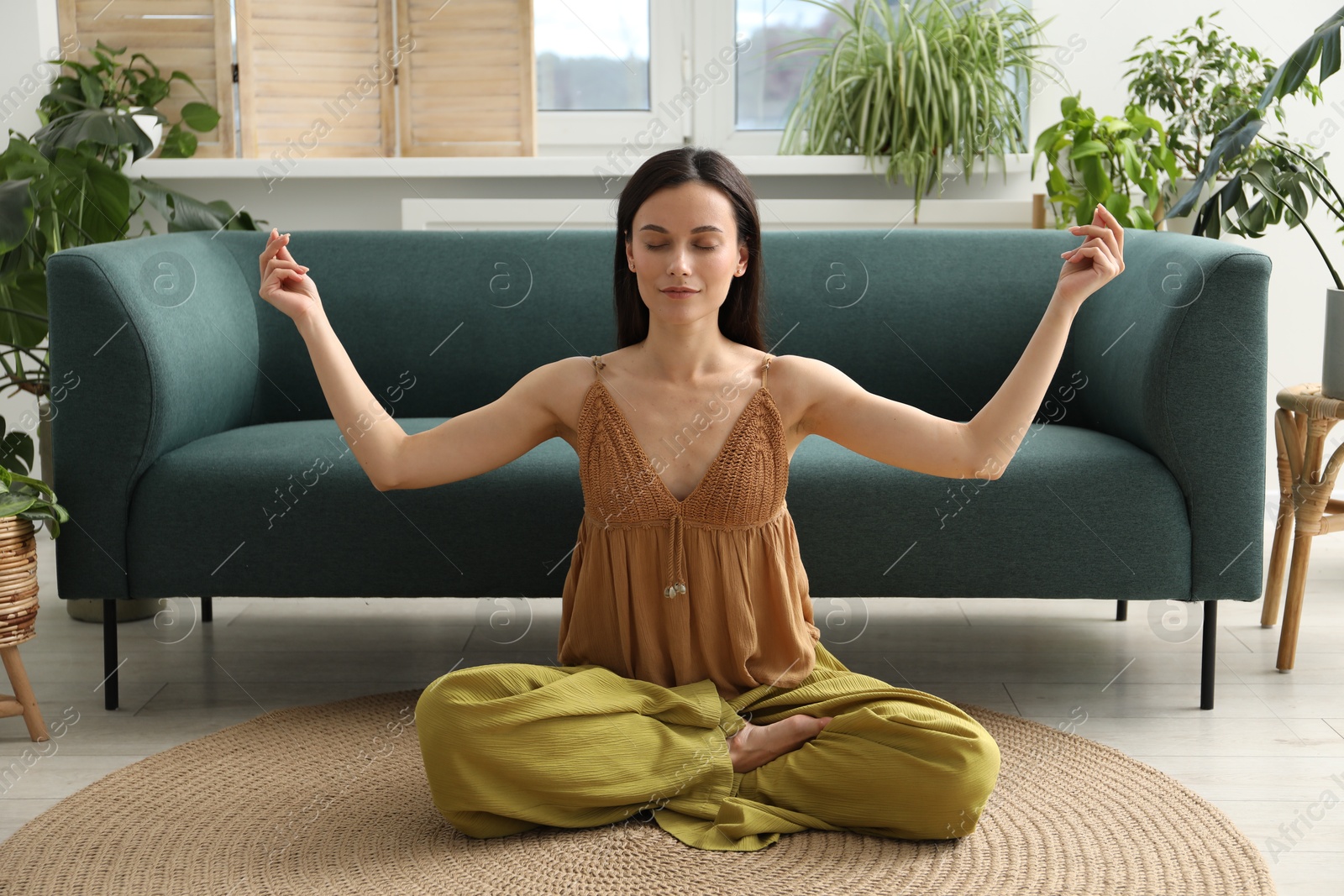 Harmony. Beautiful woman meditating on floor at home Photo of Harmony. Beautiful woman meditating on floor at home