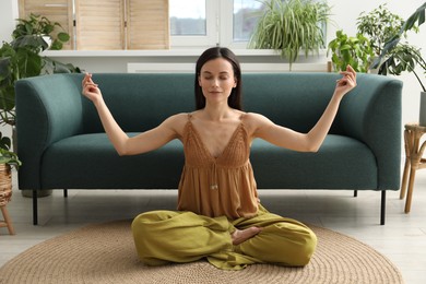 Photo of Harmony. Beautiful woman meditating on floor at home