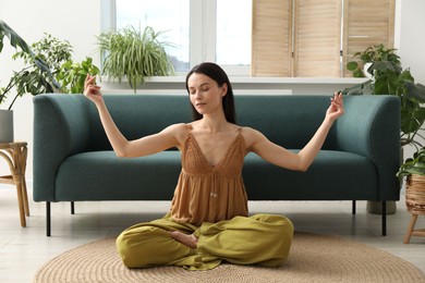 Photo of Harmony. Beautiful woman meditating on floor at home