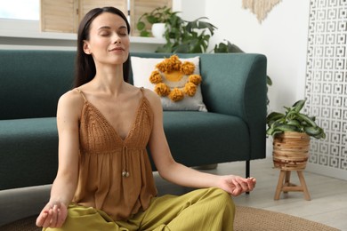 Photo of Harmony. Beautiful woman meditating on floor at home