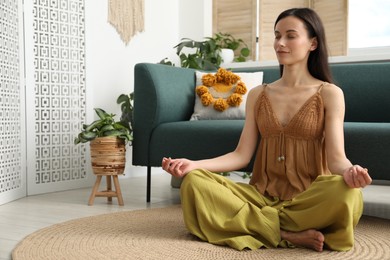 Photo of Harmony. Beautiful woman meditating on floor at home