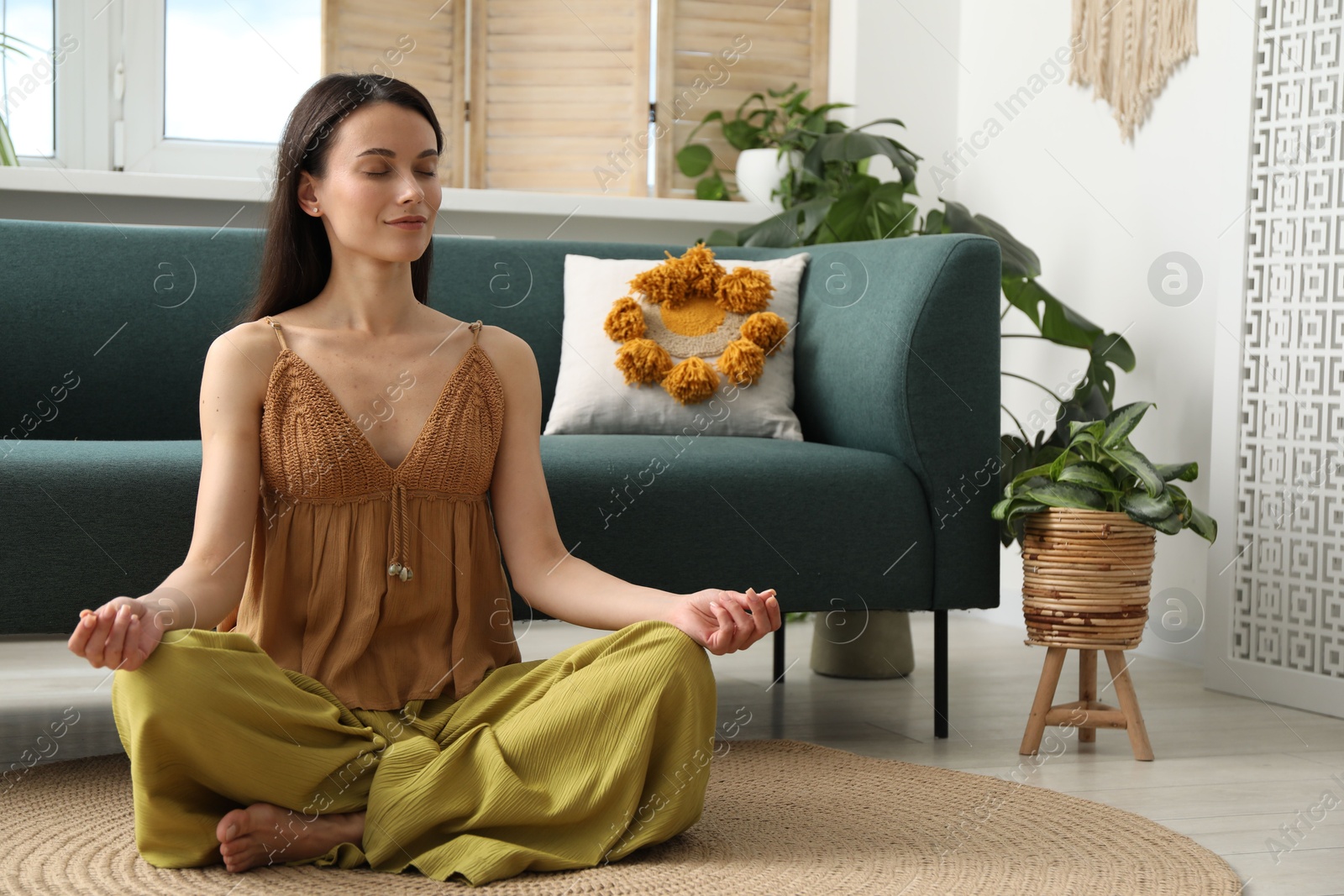 Harmony. Beautiful woman meditating on floor at home Photo of Harmony. Beautiful woman meditating on floor at home