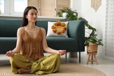 Photo of Harmony. Beautiful woman meditating on floor at home