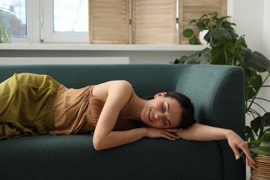 Photo of Harmony. Smiling woman relaxing on sofa at home