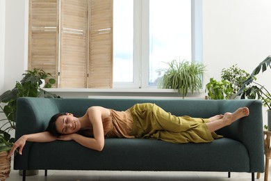 Photo of Harmony. Smiling woman relaxing on sofa at home