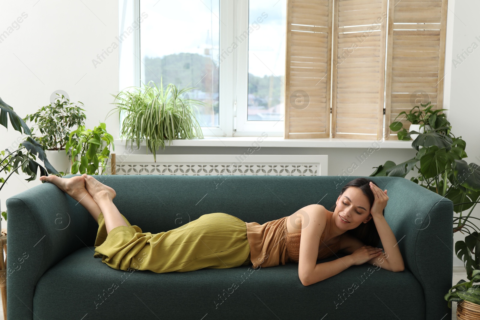 Harmony. Smiling woman relaxing on sofa at home Photo of Harmony. Smiling woman relaxing on sofa at home