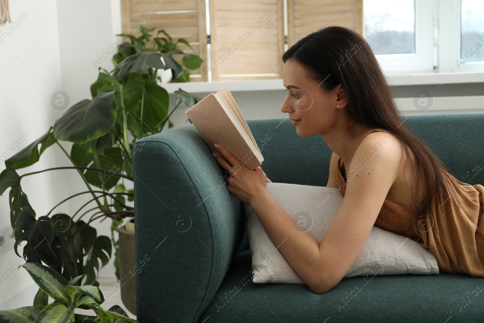 Harmony. Beautiful woman reading book on sofa at home Photo of Harmony. Beautiful woman reading book on sofa at home
