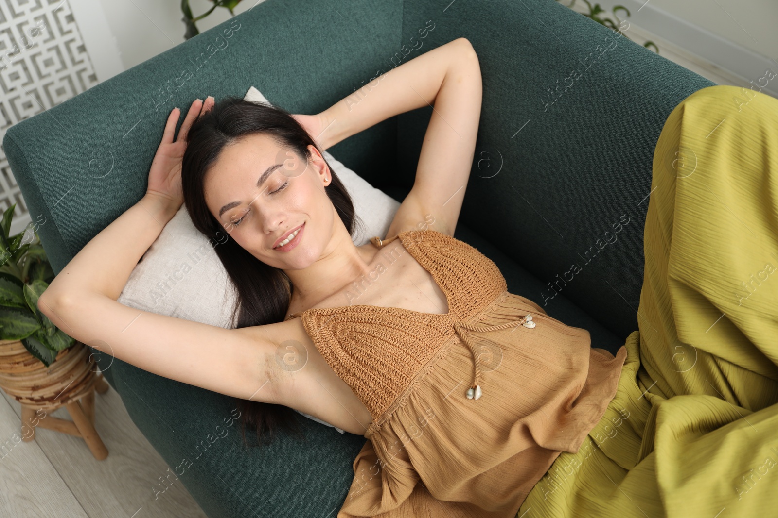 Harmony. Smiling woman relaxing on sofa at home Photo of Harmony. Smiling woman relaxing on sofa at home