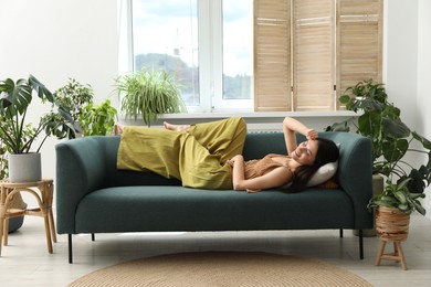Photo of Harmony. Smiling woman relaxing on sofa at home