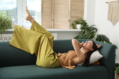 Photo of Harmony. Smiling woman relaxing on sofa at home
