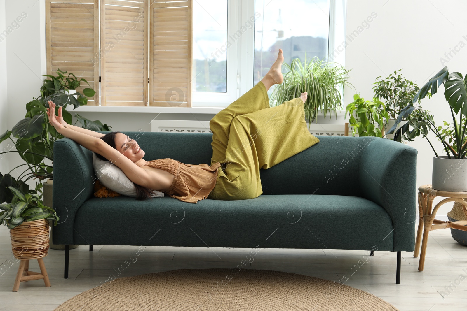 Photo of Harmony. Smiling woman relaxing on sofa at home