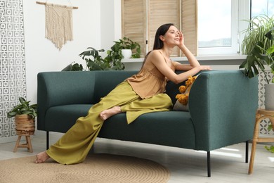 Photo of Harmony. Smiling woman relaxing on sofa at home