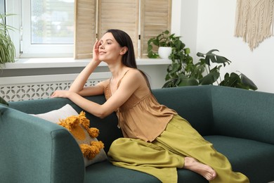 Photo of Harmony. Smiling woman relaxing on sofa at home