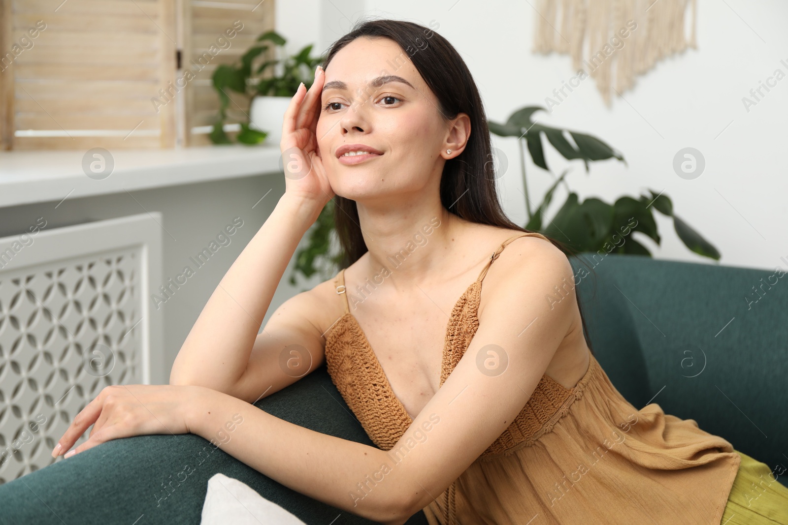 Photo of Harmony. Smiling woman relaxing on sofa at home