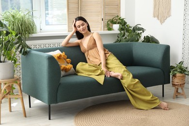 Photo of Harmony. Smiling woman relaxing on sofa at home