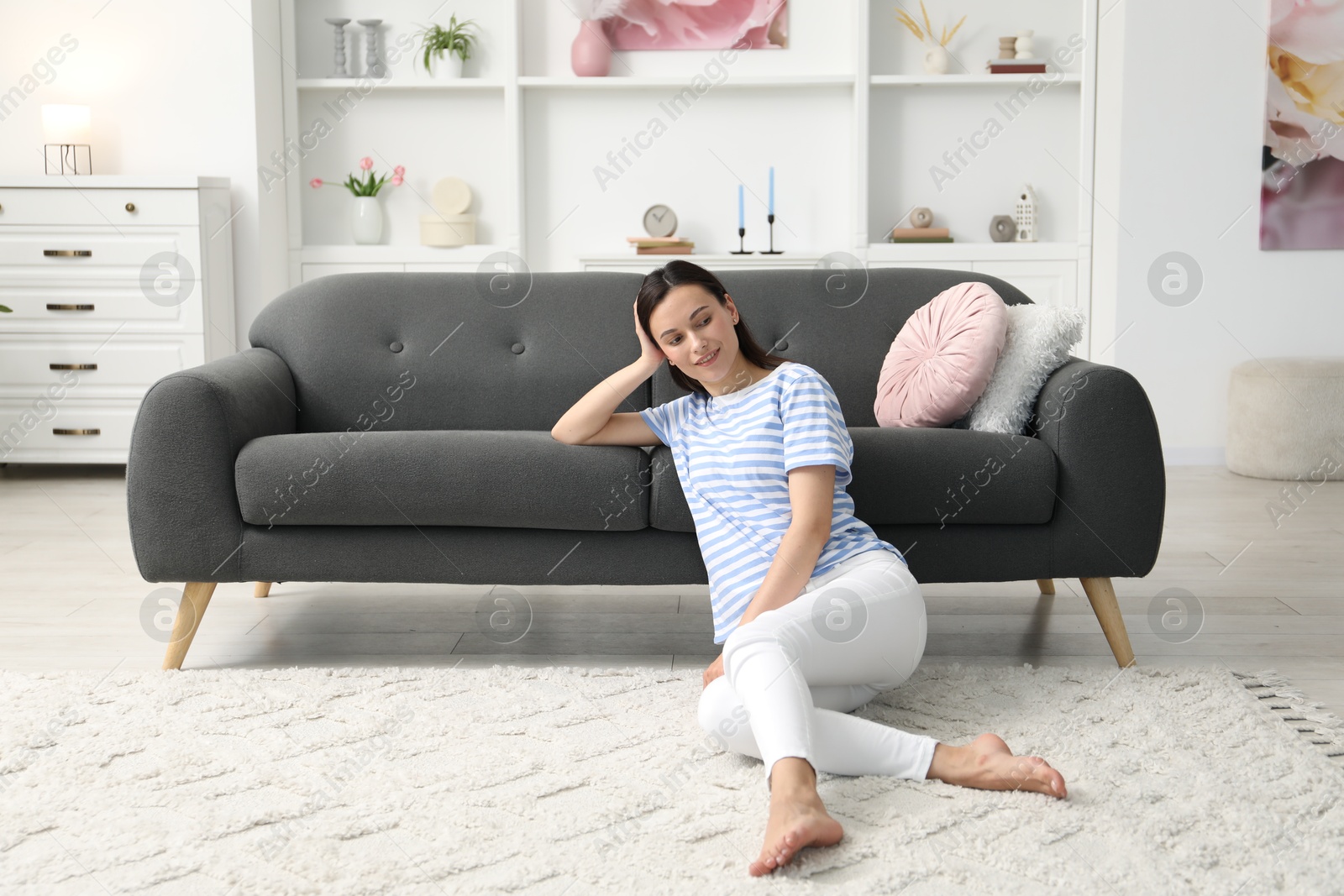 Harmony. Smiling woman relaxing while leaning on sofa at home Photo of Harmony. Smiling woman relaxing while leaning on sofa at home