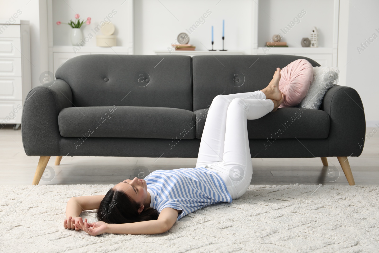 Harmony. Woman relaxing on light carpet at home Photo of Harmony. Woman relaxing on light carpet at home