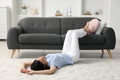 Photo of Harmony. Woman relaxing on light carpet at home