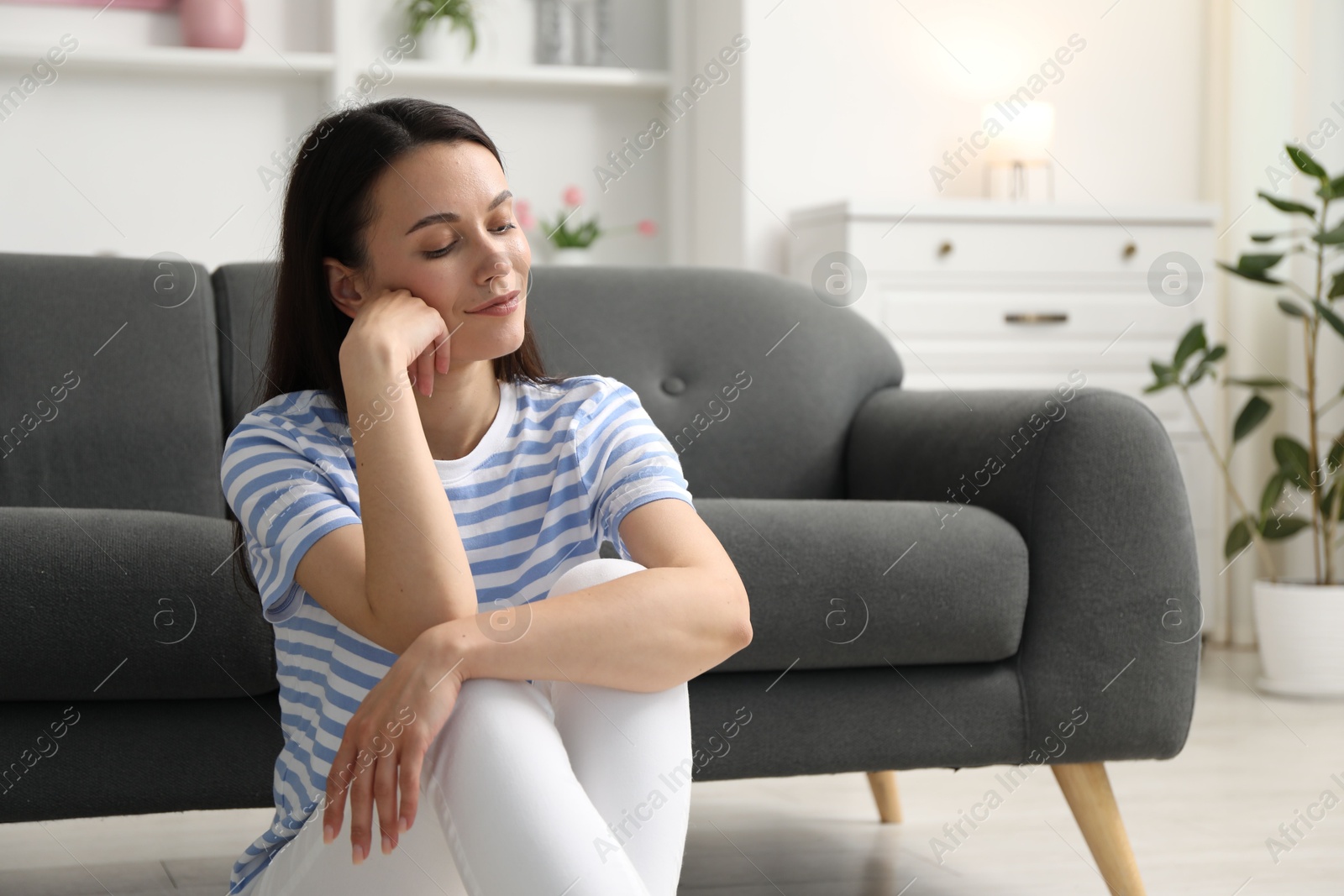 Harmony. Beautiful woman sitting on floor at home Photo of Harmony. Beautiful woman sitting on floor at home