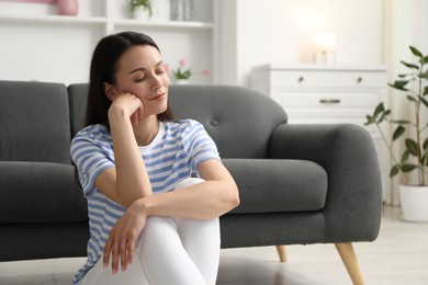 Photo of Harmony. Beautiful woman sitting on floor at home