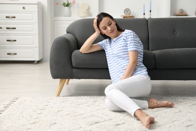 Photo of Harmony. Smiling woman sitting on floor at home