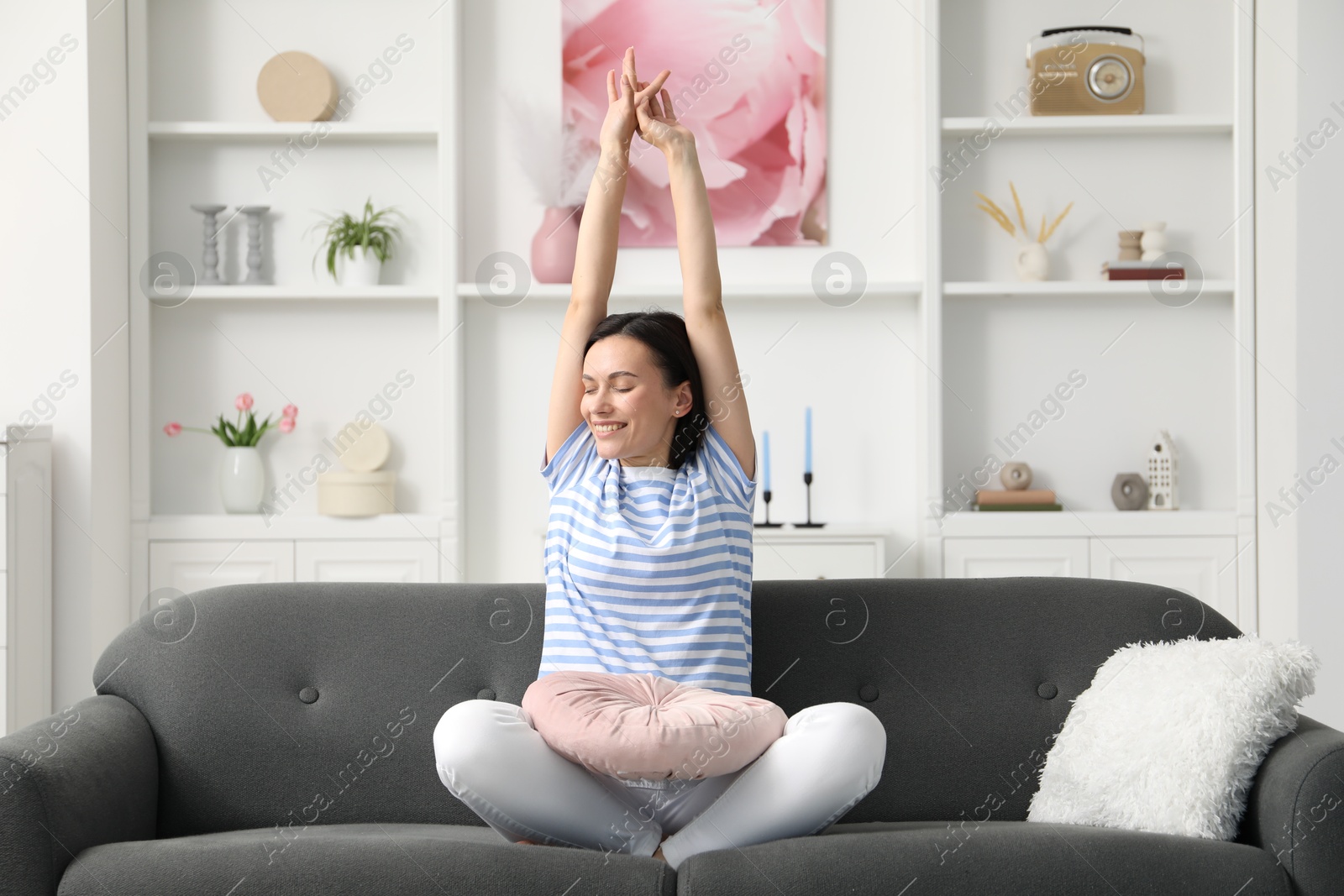 Harmony. Smiling woman stretching on sofa at home Photo of Harmony. Smiling woman stretching on sofa at home
