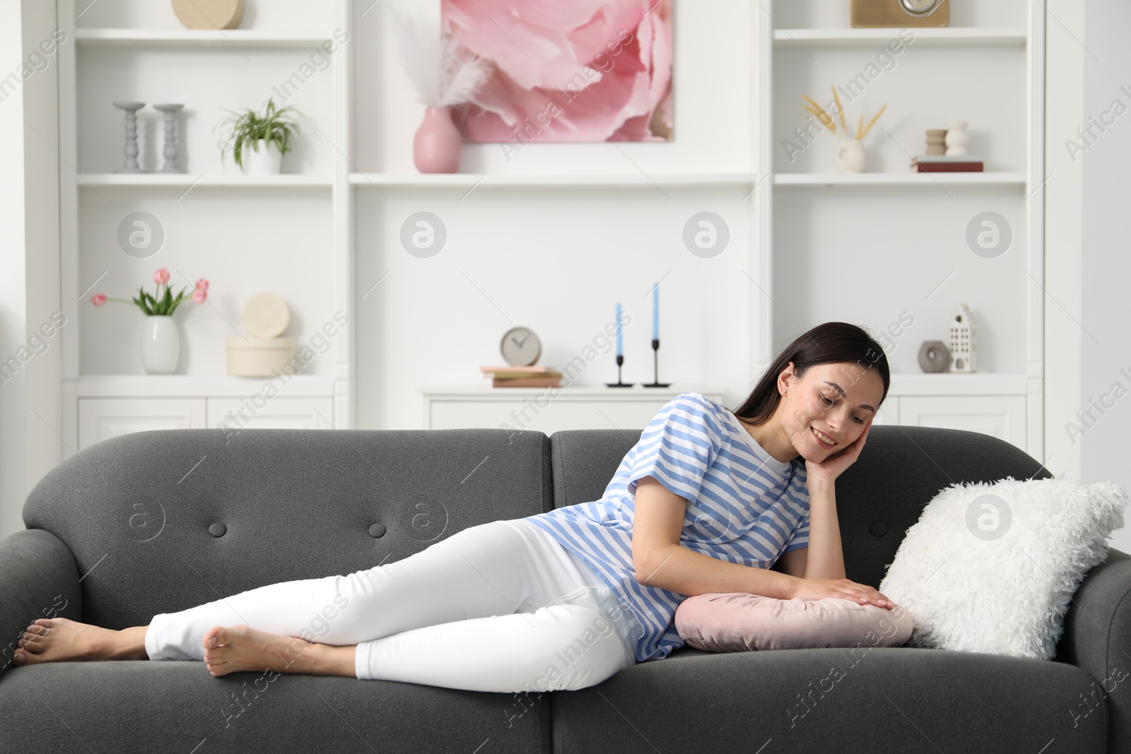 Harmony. Smiling woman lying on sofa at home Photo of Harmony. Smiling woman lying on sofa at home