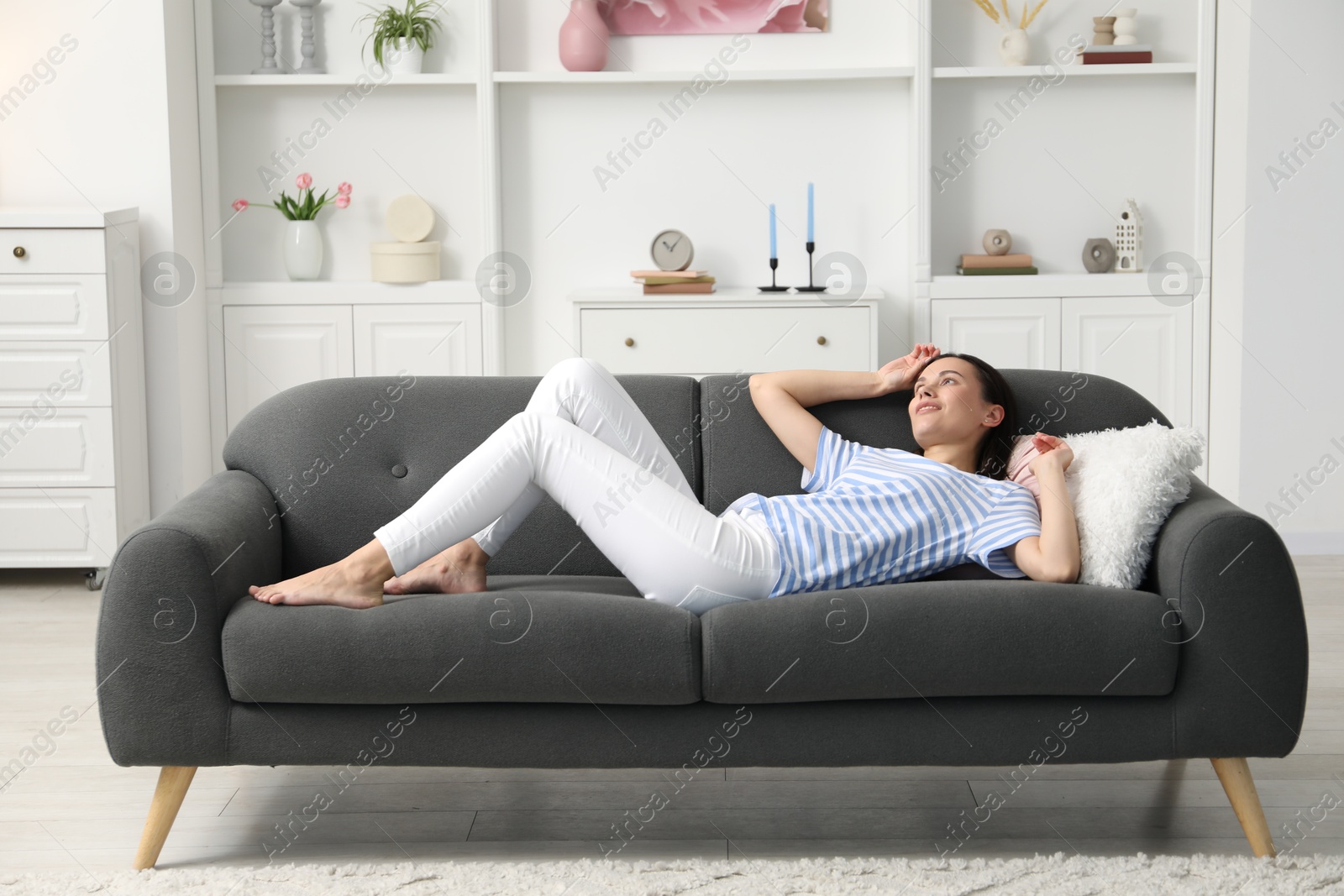 Harmony. Smiling woman lying on sofa at home Photo of Harmony. Smiling woman lying on sofa at home