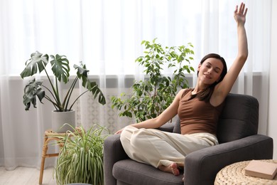 Photo of Harmony. Smiling woman relaxing on armchair at home