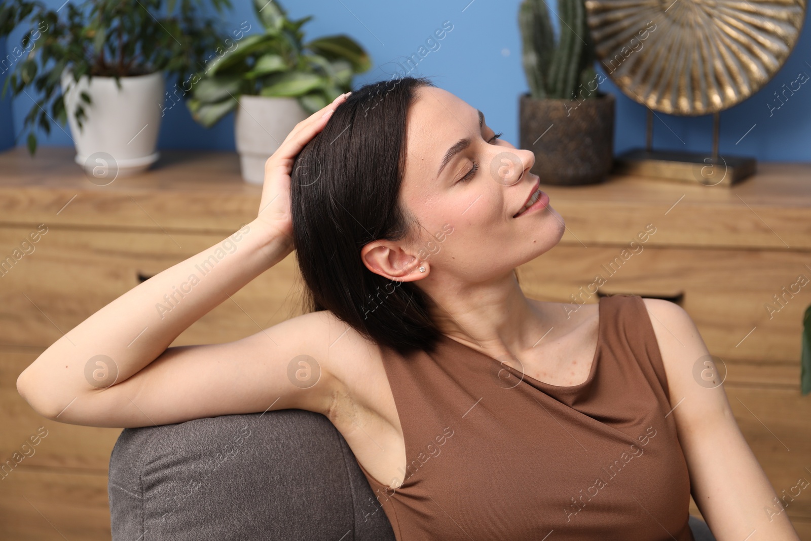 Harmony. Smiling woman relaxing on armchair at home Photo of Harmony. Smiling woman relaxing on armchair at home