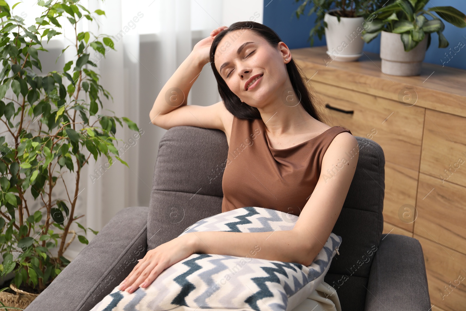 Harmony. Smiling woman relaxing on armchair at home Photo of Harmony. Smiling woman relaxing on armchair at home