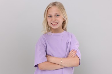 Photo of Portrait of happy girl on light grey background in photo studio