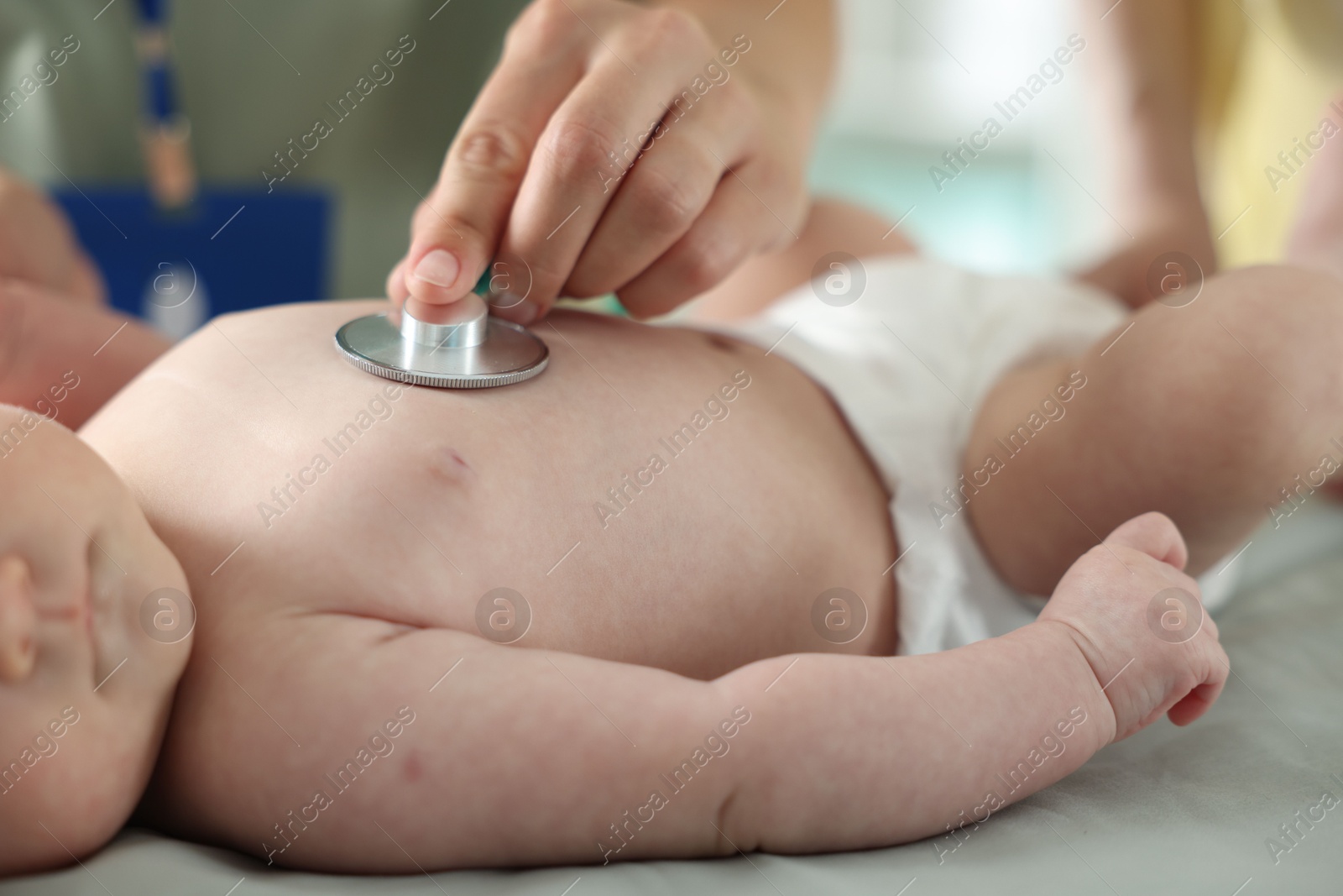 Mother and her cute little child having appointment with pediatrician in hospital. Doctor examining baby with stethoscope, closeup Photo of Mother and her cute little child having appointment with pediatrician in hospital. Doctor examining baby with stethoscope, closeup
