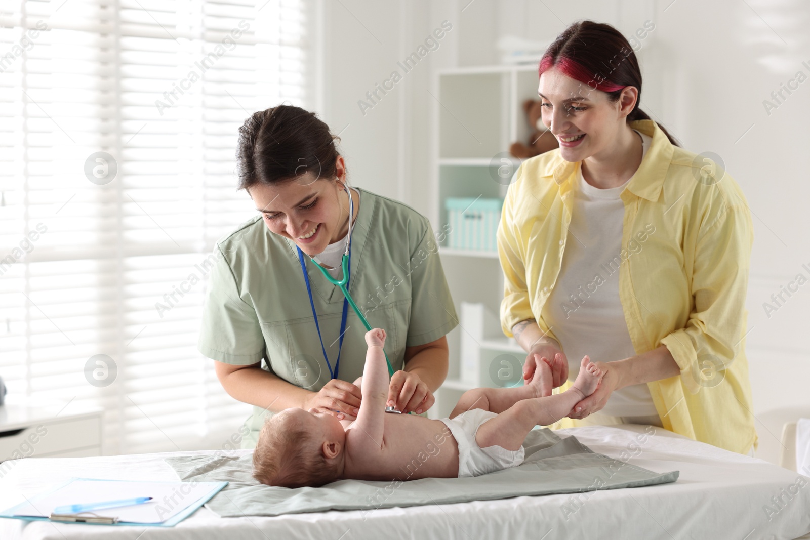 Mother and her cute little child having appointment with pediatrician in hospital. Doctor examining baby with stethoscope Photo of Mother and her cute little child having appointment with pediatrician in hospital. Doctor examining baby with stethoscope