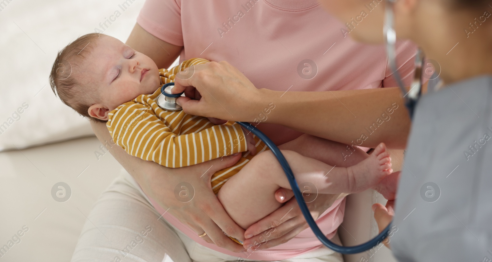 Mother and her cute little child having appointment with pediatrician in hospital. Doctor examining baby with stethoscope, closeup Photo of Mother and her cute little child having appointment with pediatrician in hospital. Doctor examining baby with stethoscope, closeup