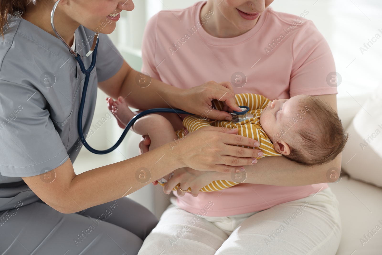 Mother and her cute little child having appointment with pediatrician in hospital. Doctor examining baby with stethoscope, closeup Photo of Mother and her cute little child having appointment with pediatrician in hospital. Doctor examining baby with stethoscope, closeup
