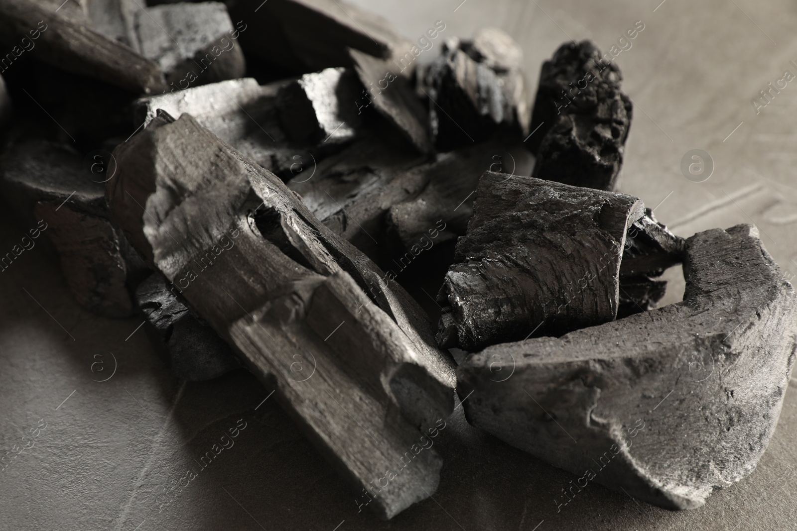 Pieces of black coals on grey table, closeup Photo of Pieces of black coals on grey table, closeup