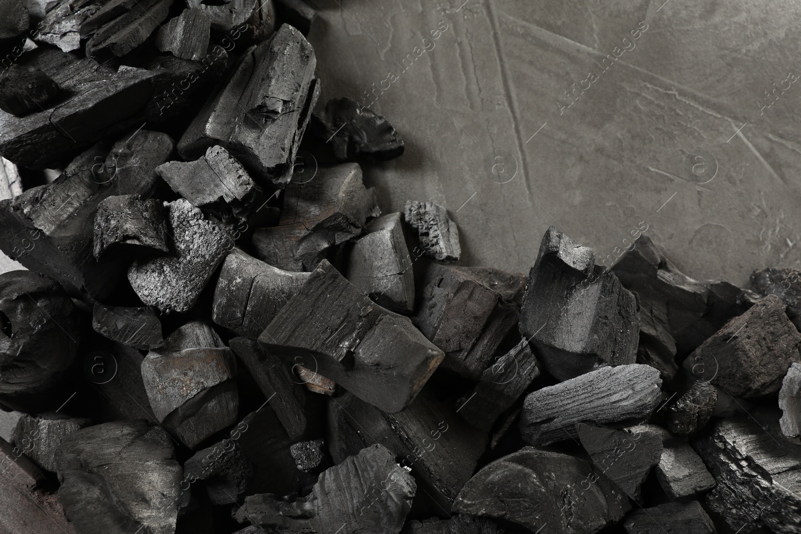 Pieces of black coals on grey table, flat lay Photo of Pieces of black coals on grey table, flat lay