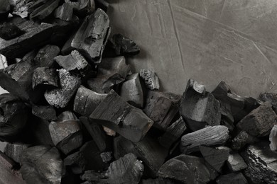 Photo of Pieces of black coals on grey table, flat lay